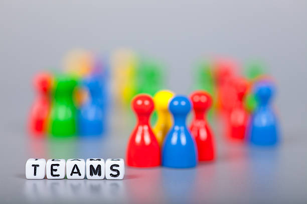 istock Cube Letters show teams  in front of unsharp ludo figures 472509682