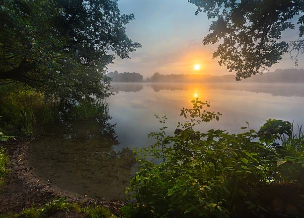 istock Beautiful sunrise over misty lake. 472511454