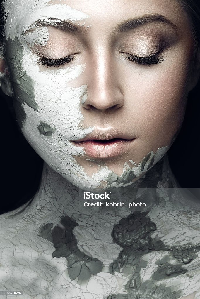 Beautiful woman with silver cosmetic mask covering her face Beautiful girl with mud on his face. Cosmetic mask. Beauty face. Picture taken in the studio on a black background. Facial Mask - Beauty Product Stock Photo