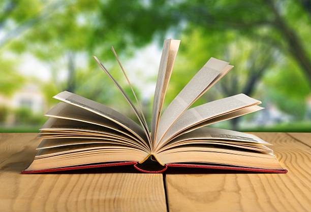istock Book. Open book on wood planks over abstract light background 472518038