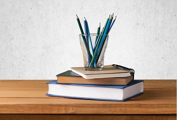 istock Old vintage book, note book and blue pencils on wooden 472518210
