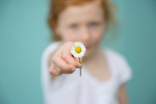 istock Redhead girl offers a white flower 472523176