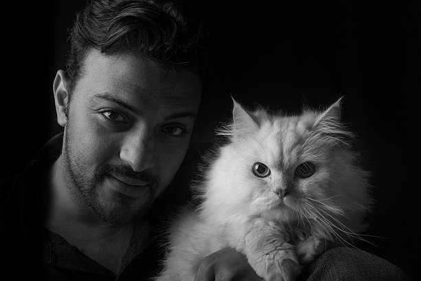 istock Man with a Persian Cat - Monochrome and wide composition 472523412