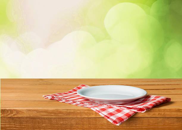 istock Empty white plate on wooden table over red grunge background 472533232