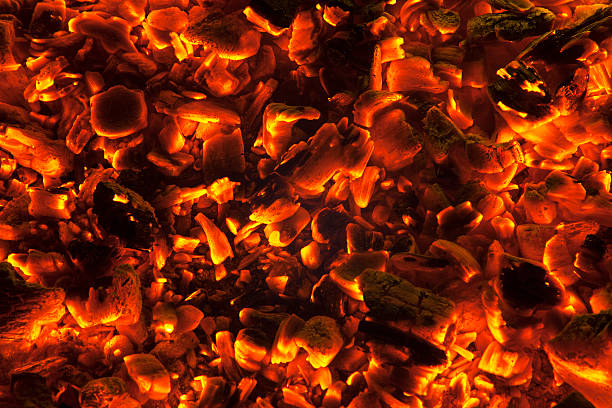 Wood embers burning background, close-up stock photo