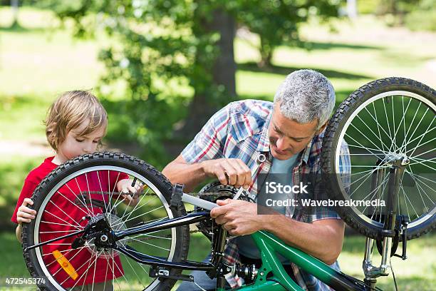 Father And His Son Fixing A Bike Stock Photo - Download Image Now - 2015, 30-39 Years, 35-39 Years