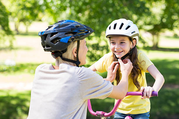istock Mother attaching her daughters cycling helmet 472546740
