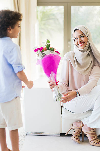 istock Son is giving flowers to her mother as a present. 472547278