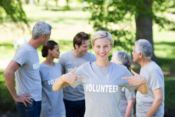 istock Happy volunteer blonde smiling at the camera 472551138