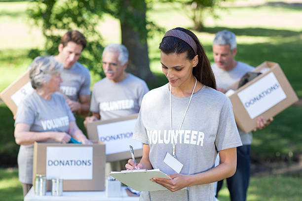 istock Smiling volunteer brunette writing on cipboard 472551552