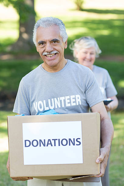 istock Happy volunteer senior holding donation box 472551586