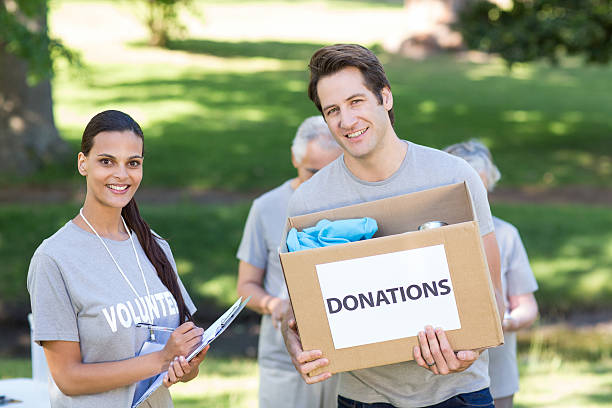 istock Happy volunteer man holding donation box 472551608