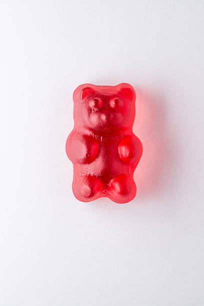 istock Red gummy bear candy on white paper 472555958
