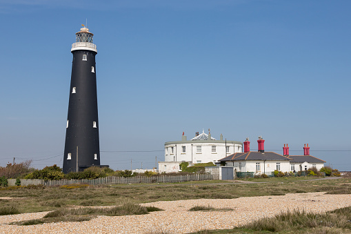 Old Dungeness Lighthouse and houses at  Dungeness, Romney Marsh, Kent England Photo taken on April 07, 2015