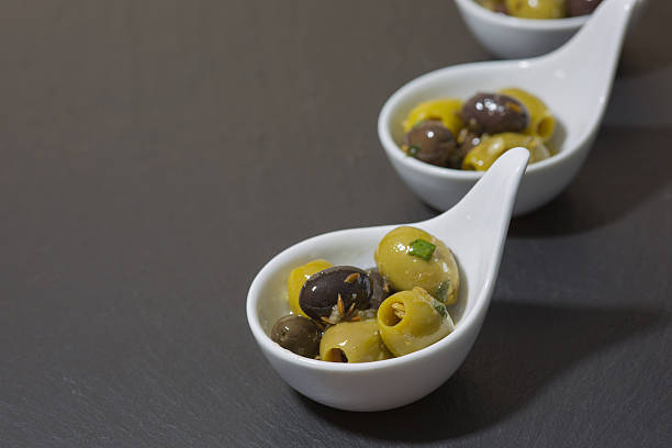 istock green and black olives with spices on slate plate 472566578