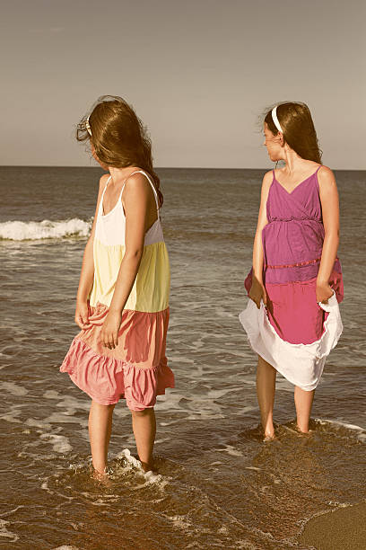 istock Two young girls watching over his shoulder into the  sea 472573328