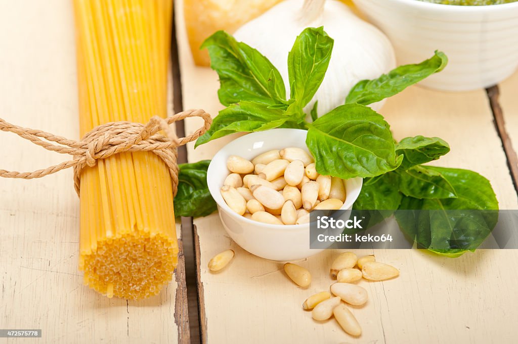 Italian traditional basil pesto pasta ingredients Italian traditional basil pesto pasta ingredients parmesan cheese pine nuts extra virgin olive oil garlic on a rustic table 2015 Stock Photo