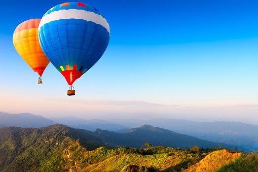 Stunning morning view and balloons in Cappadocia taking off at sunrise. Every day over 100 balloons fly taking tourist on a magical view of Nevsehir.