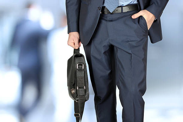 istock Businessman walking and holding  a  leather briefcase in his hand 472579596