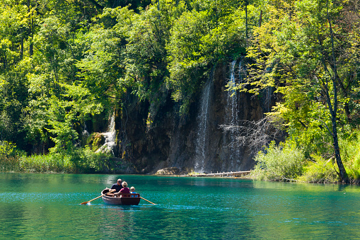 Plitvica Selo, Croatia - July 28, 2013: Tourists on a boat to enjoy the views of waterfalls in Plitvice Lakes National Park, Croatia. Plitvice Lakes - National Park in Croatia, located in the central part of the country. Since 1979, the national park 