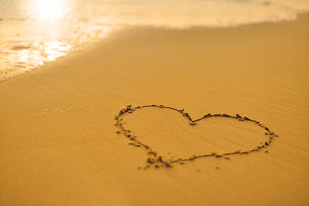istock Beach scene with heart in the sand 472584060