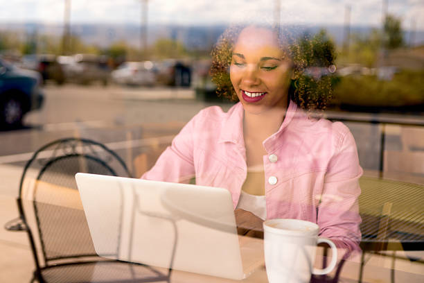 istock Pretty Mixed Race Young Woman Using Laptop Through Window View 472587116