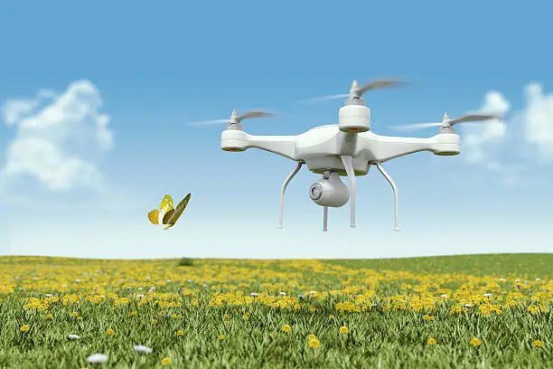 Photo of Quadrocopter drone with a camera filming a butterfly