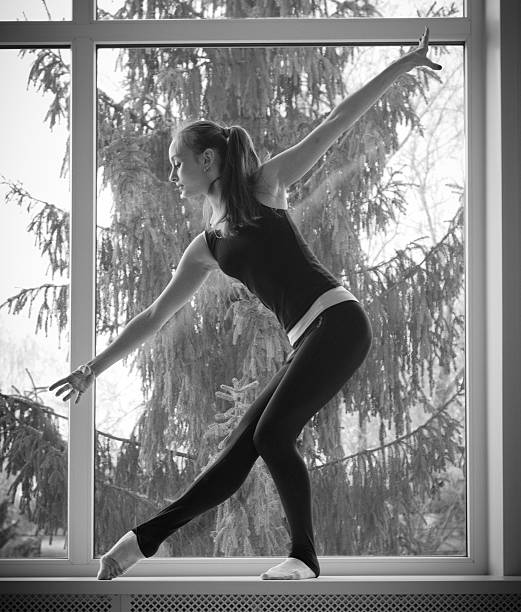 istock Girl engaged art gymnastic on window 472592468