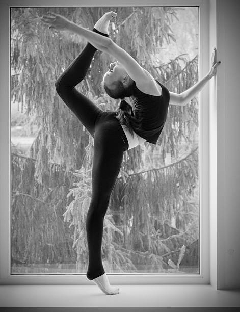 istock Girl engaged art gymnastic on window 472593040