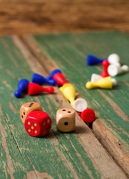 istock Three dices and color figurines on old wooden board 472595030