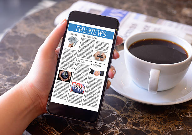ręka trzyma smartphone wyświetlanie aktualności - newspaper the media reading digital display zdjęcia i obrazy z banku zdjęć