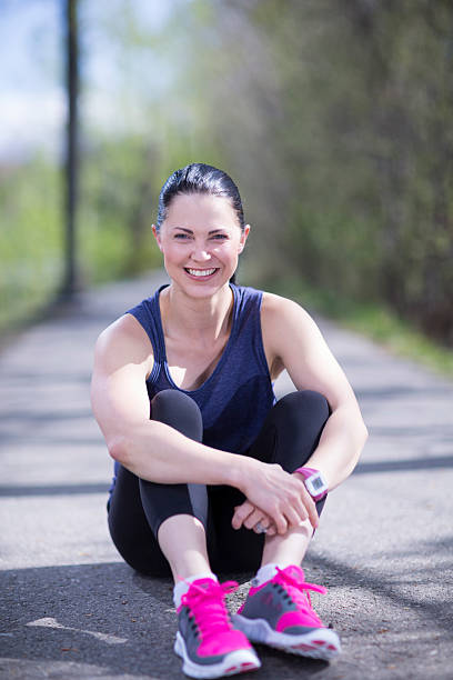 istock Athletic woman resting after a run 472596320