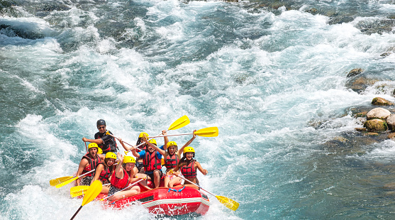 Group of people white water rafting. The raft goes through a big rapid on Koprulu Canyon near Antalya, Turke