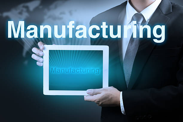 istock businessman holding tablet showing word MANUFACTURING on virtual screen. 472604212