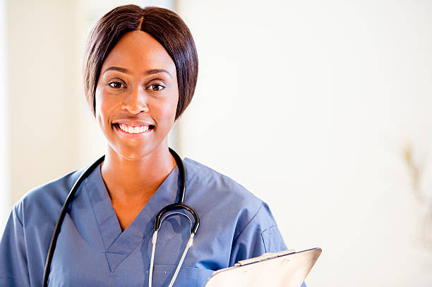 istock Smiling Nurse with Clip Board 472605256
