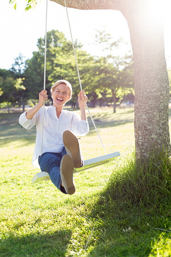 Happy blonde swing on a sunny day 