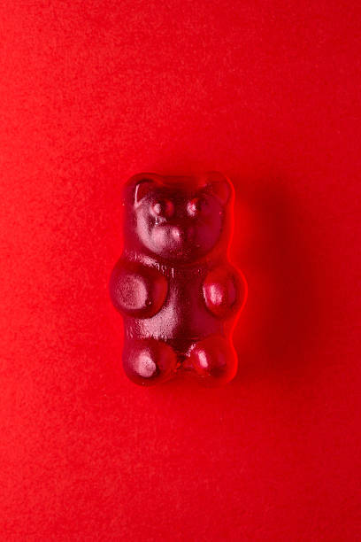istock Red gummy bear candy on red paper 472609754