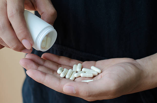 istock picture of hands holding white pack and pills 472610238
