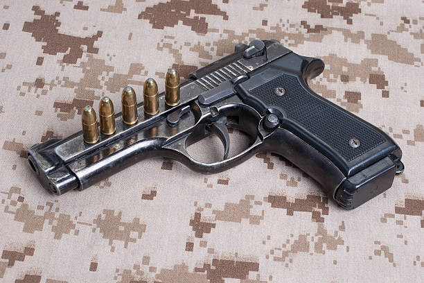 istock Beretta hand gun on  desert marines uniform 472611794