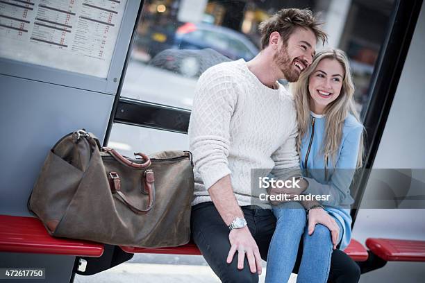 Loving Couple Sitting At The Bus Stop Stock Photo - Download Image Now - Couple - Relationship, Bus, Bus Stop