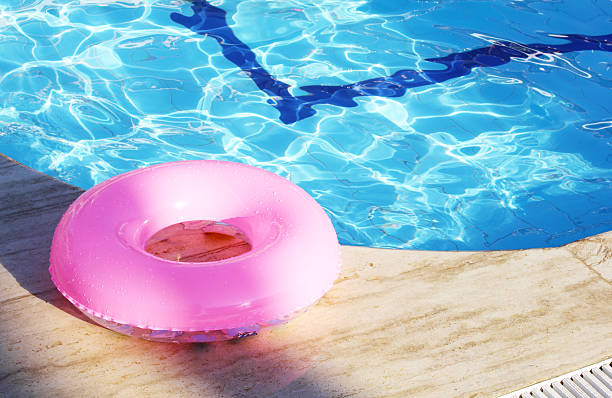 кольцо floating на краю бассейна - swimming pool toy inflatable ring float стоковые фото и изображения