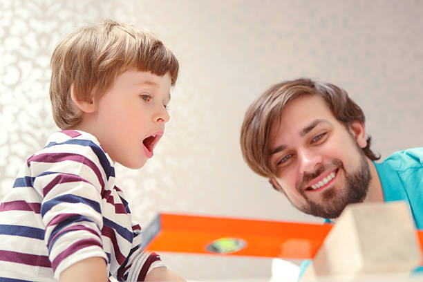 istock Father and son play with a building kit 472628930