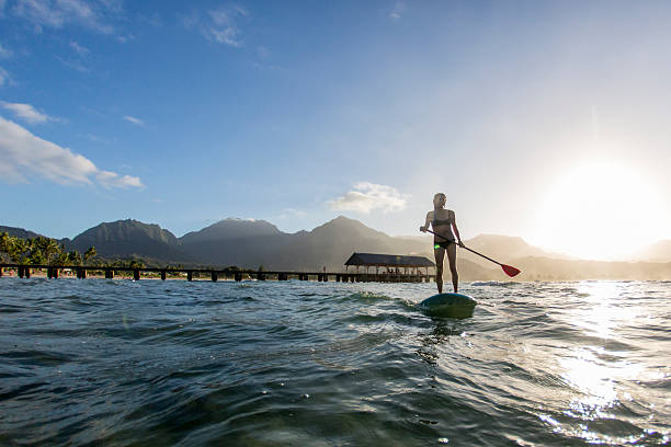 Woman Paddle Boarding in the Sun