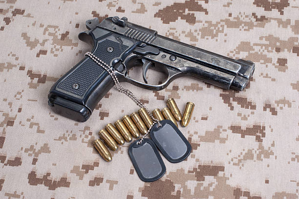 istock Beretta hand gun on  desert marines uniform 472629308