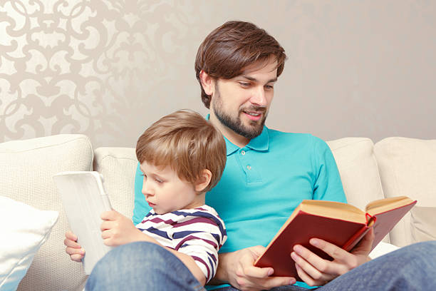 istock Father and son read a book or tablet 472629544