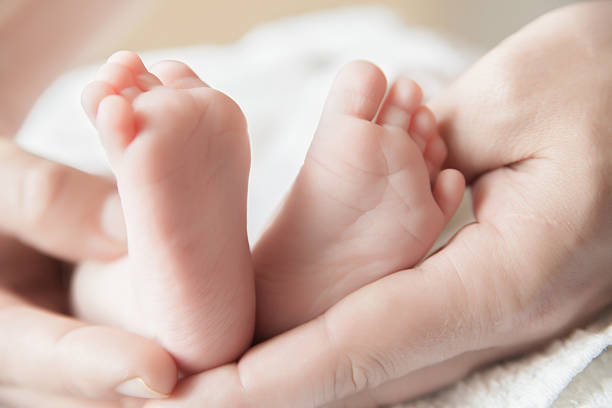 istock Parent holding his newborn baby's feet 472630612