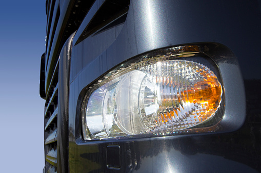 Close up of truck headlight, with a clear sky back drop.