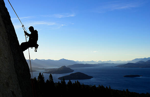 A silhouette of a man rock climbing in Patagonia stock photo