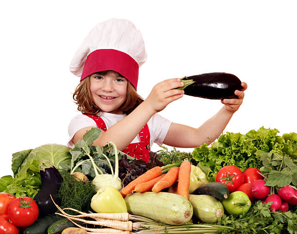 istock little girl cook holding eggplant 472635810