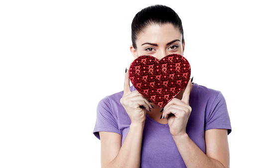 Woman hiding her face with heart shape gift box